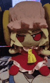 a stuffed doll with a red dress and a yellow bow