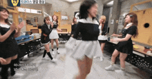 a group of girls are dancing in a room with a yellow sign that says twice