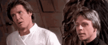 han solo and luke skywalker are standing next to each other and looking at each other .