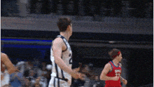 a basketball player wearing a smu jersey is running towards another player