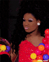 a woman in a red dress is holding a container of candy