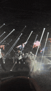 a group of people are dancing on a stage in front of a large screen that says t