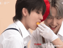 a couple of boys are eating something with yuma written on the bottom