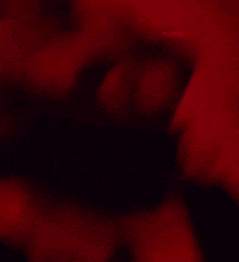 a close up of a woman 's face with a red light behind her and the word azats on the bottom