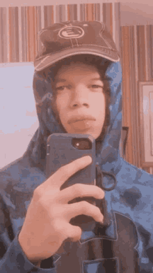 a person wearing a hat and a hoodie taking a selfie