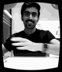 a man with a mustache is wearing a black shirt