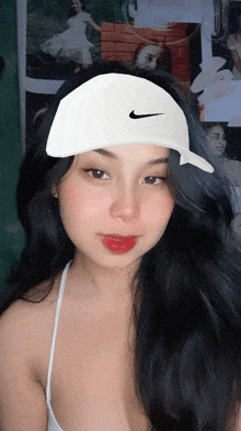 a woman wearing a white nike hat and a white top