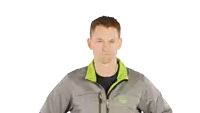 a man wearing a grey jacket with a green collar that says ' jc ' on the front