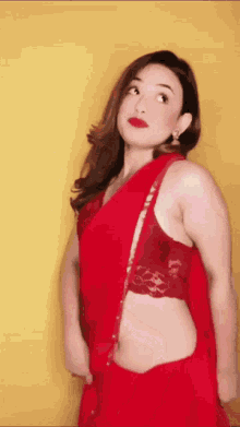 a woman is wearing a red saree with a lace top