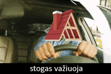 a man is driving a car with a red roof and the word stogas written below him