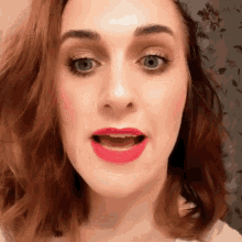 a close up of a woman 's face with red lipstick on her lips