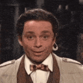 a man wearing a suit and bow tie is smiling .