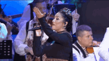 a woman is singing into a microphone while a man plays an accordion