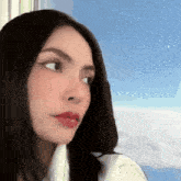 a close up of a woman 's face looking out of a window