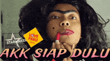 a woman is applying lipstick and the words akk siap dulu are on the bottom right
