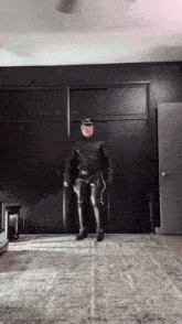 a man in a leather suit is standing in a room