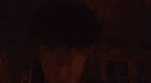 a person 's face is visible in the dark with a blurry background
