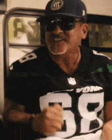a man wearing a new york jets jersey and a hat