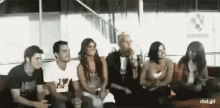 a group of people are sitting on a couch in a room .