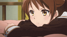 a girl with brown hair and yellow eyes is laying down