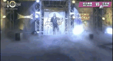 a man in a black suit is walking on a stage in front of a sign that says stardom .