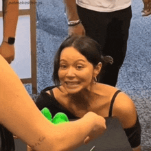 a woman with a tattoo on her arm is smiling while being held by a man .