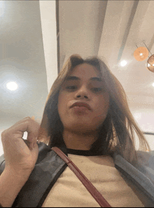 a woman with long hair looks at the camera while holding her hair