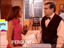 a woman in a pink dress is talking to a man in a black vest with the word pergunta on the bottom
