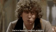a man with curly hair is talking and saying `` you 're a beautiful woman , probably '' .