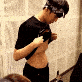 a man with a bandana on his head takes off his shirt