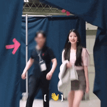 a woman in a pink shirt is walking through a doorway with a red arrow pointing to the right