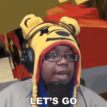 a woman wearing a winnie the pooh hat and headphones says " let 's go "