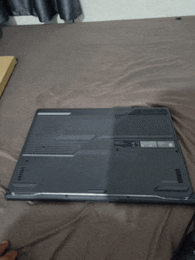 a laptop is laying on a bed and the back of the laptop has a sticker that says ' ce ' on it