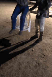 a man in a plaid shirt is standing next to a man in a chair