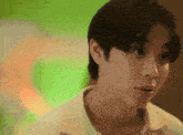 a close up of a man 's face with a green background behind him