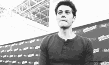 a man is standing in front of a comic con wall