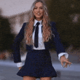 a woman in a school uniform with a tie