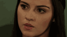 a close up of a woman 's face with dark hair and red lips