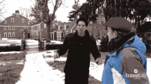 a man in a blue travel hd jacket talks to a man in a black jacket