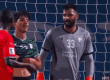 a soccer player with the number 33 on his jersey talks to another player