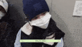 a girl wearing a mask and a hat is sitting next to another girl .