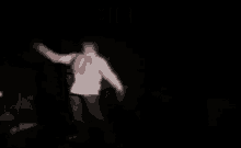a blurred image of a person in a white hoodie in a dark room with the word umiera above them .