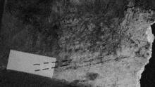 a black and white photo of a rock with a piece of paper that says zzz