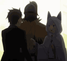 a man in a suit stands next to a woman in a white cape with cat ears
