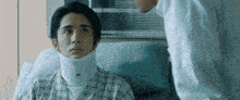 a man is laying in a hospital bed with a neck brace on his neck .