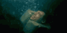a man in a life jacket is swimming in the water .