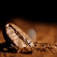 a close up of a coffee bean on a pile of coffee beans on a table .