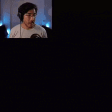a man wearing headphones is on a screen with the words five nights at freddy 's created above him
