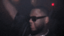 a blurry picture of a person in a dark room with a red light in the background .