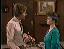 a man and woman are standing next to each other in a room .
